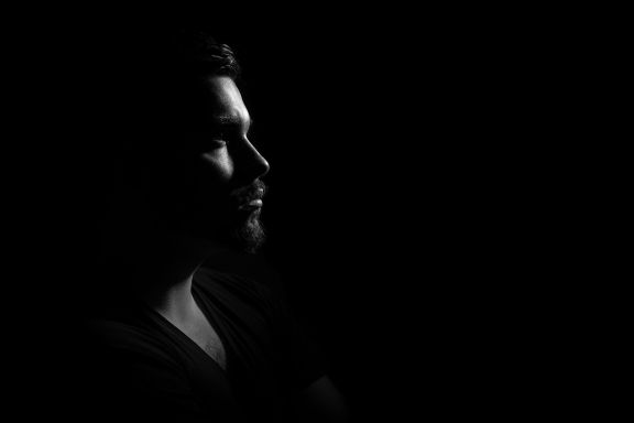 man meditating in dark room